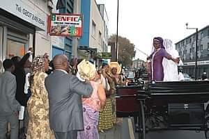 Apostle Bimpe dancing on a cart while well wishers cheer her